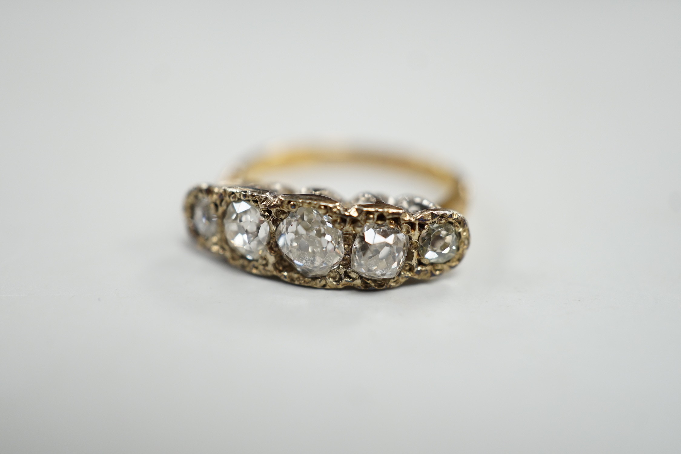 An 18ct, plat and graduated five stone diamond set half hoop ring, size J/K, gross weight 3.3 grams.